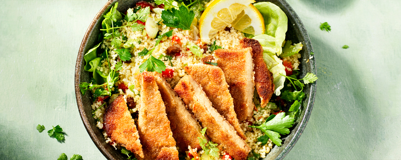 Hälsans Kök Vegan Schnitzel served over couscous with herbs and lemon slices