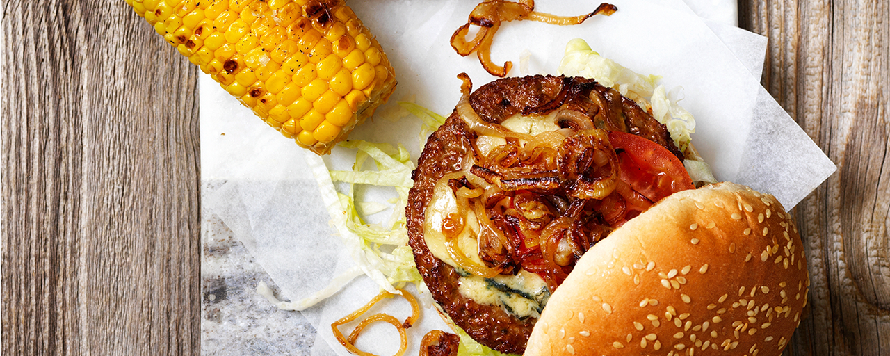 Hälsans Kök Vegoburger served with grilled corn and caramelized onions