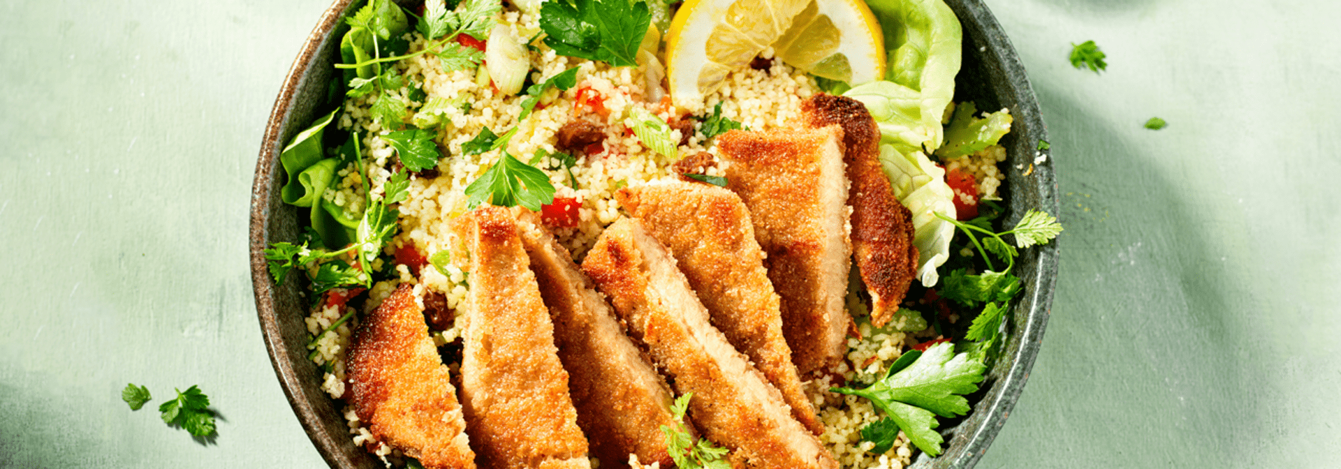 Hälsans Kök Vegan Schnitzel served over couscous with herbs and lemon slices