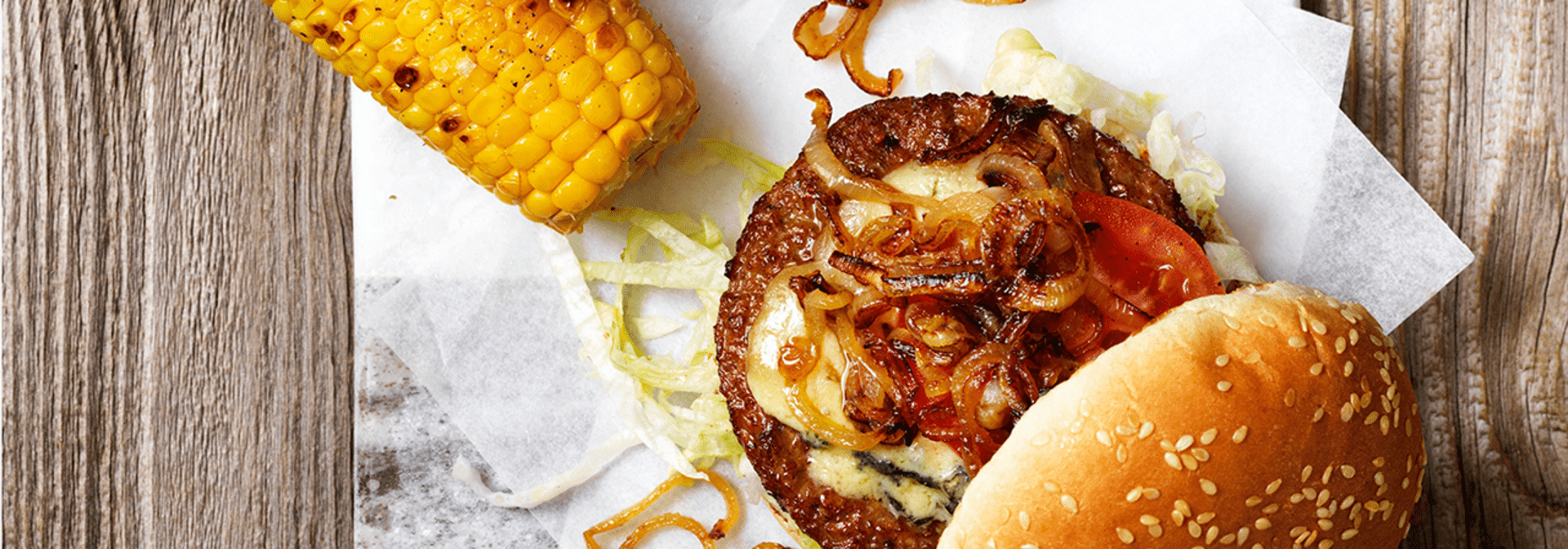 Hälsans Kök Vegoburger served with grilled corn and caramelized onions