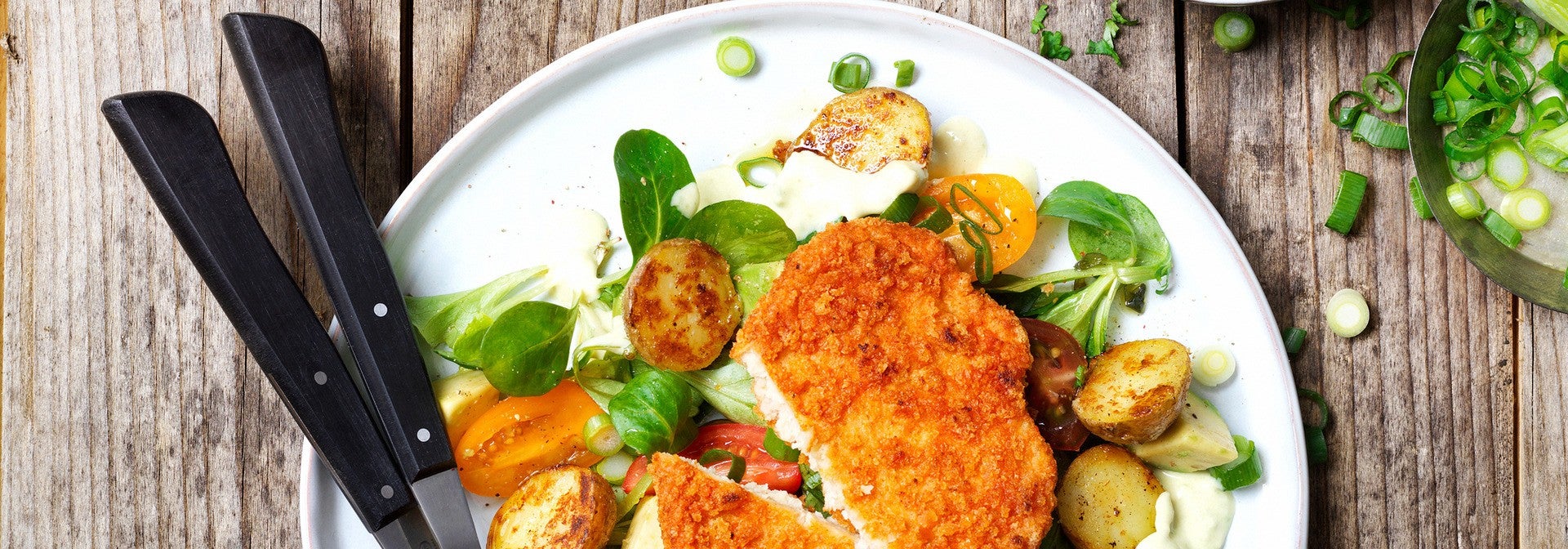 Schnitzel with baked baby potatoes with tomato salad and avocado dressing