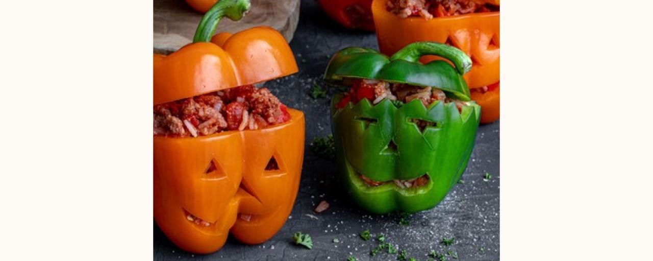 Peppers cut as a pumpkins with scary faces filled with mixture of Garden Gourmet Minced, rive and beans
